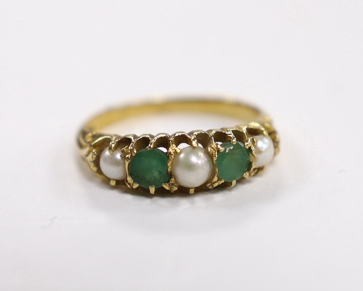 An 18ct, two stone emerald and three stone split pearl set half hoop ring, size P, gross weight 4.1 grams.
